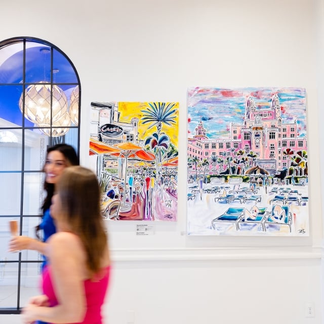 two women walking through an art gallery