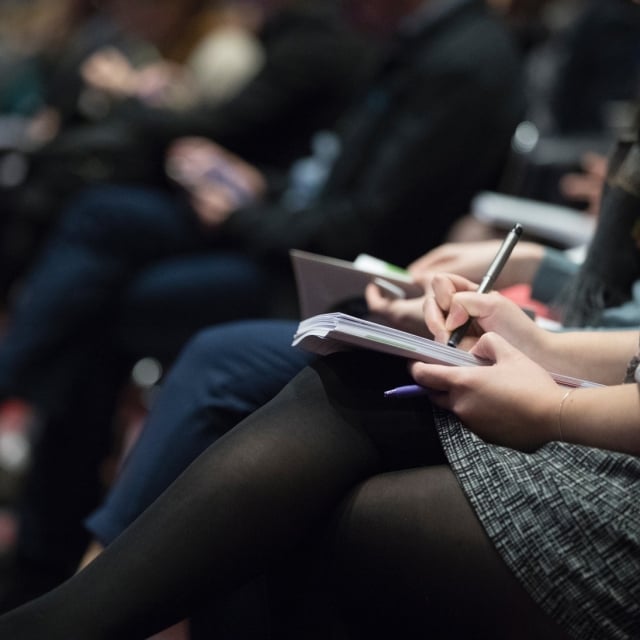 A woman taking notes at a conference