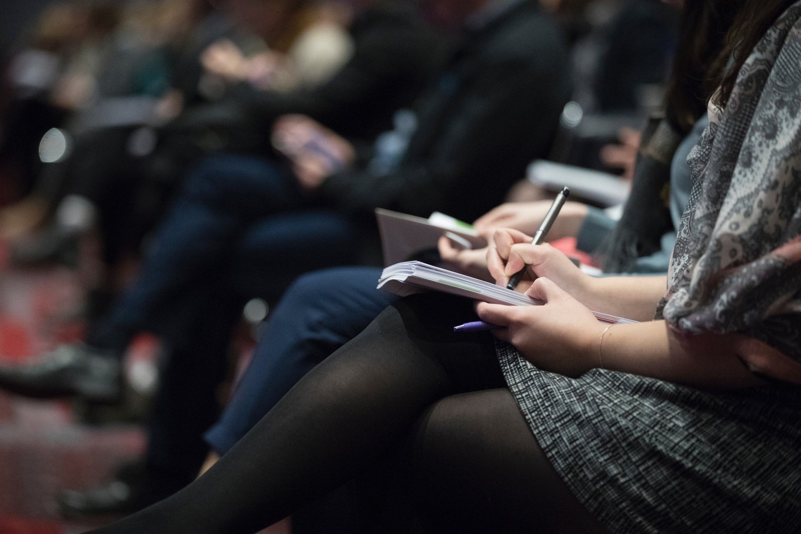 A woman taking notes at a conference