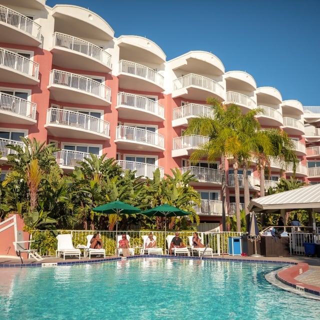 people sitting on lounge chairs by the pool