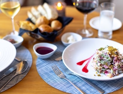 A plate of salad with a small dish of dressing