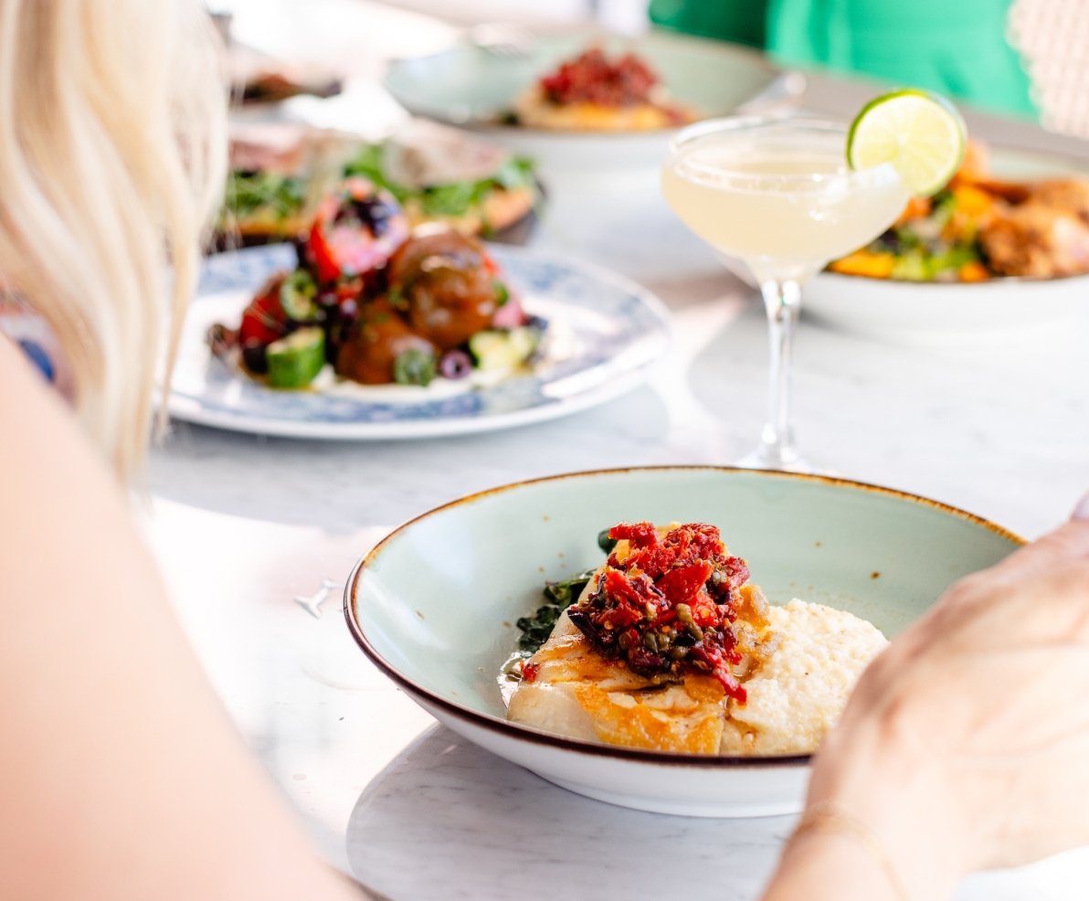 woman eating a meal and drinking a cocktail