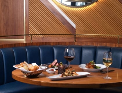 a table with plates of food and two glasses of wine