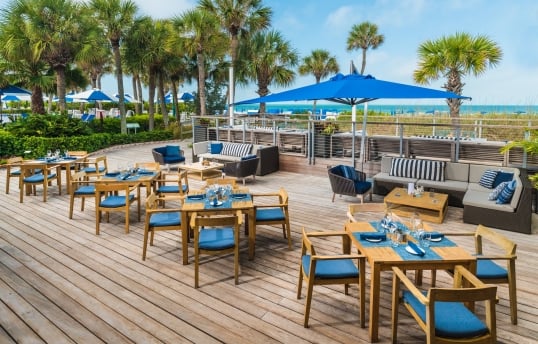 outdoor dining area with wooden tables and hints of blue