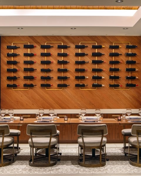 a private dining area with various bottles of wine on the wall