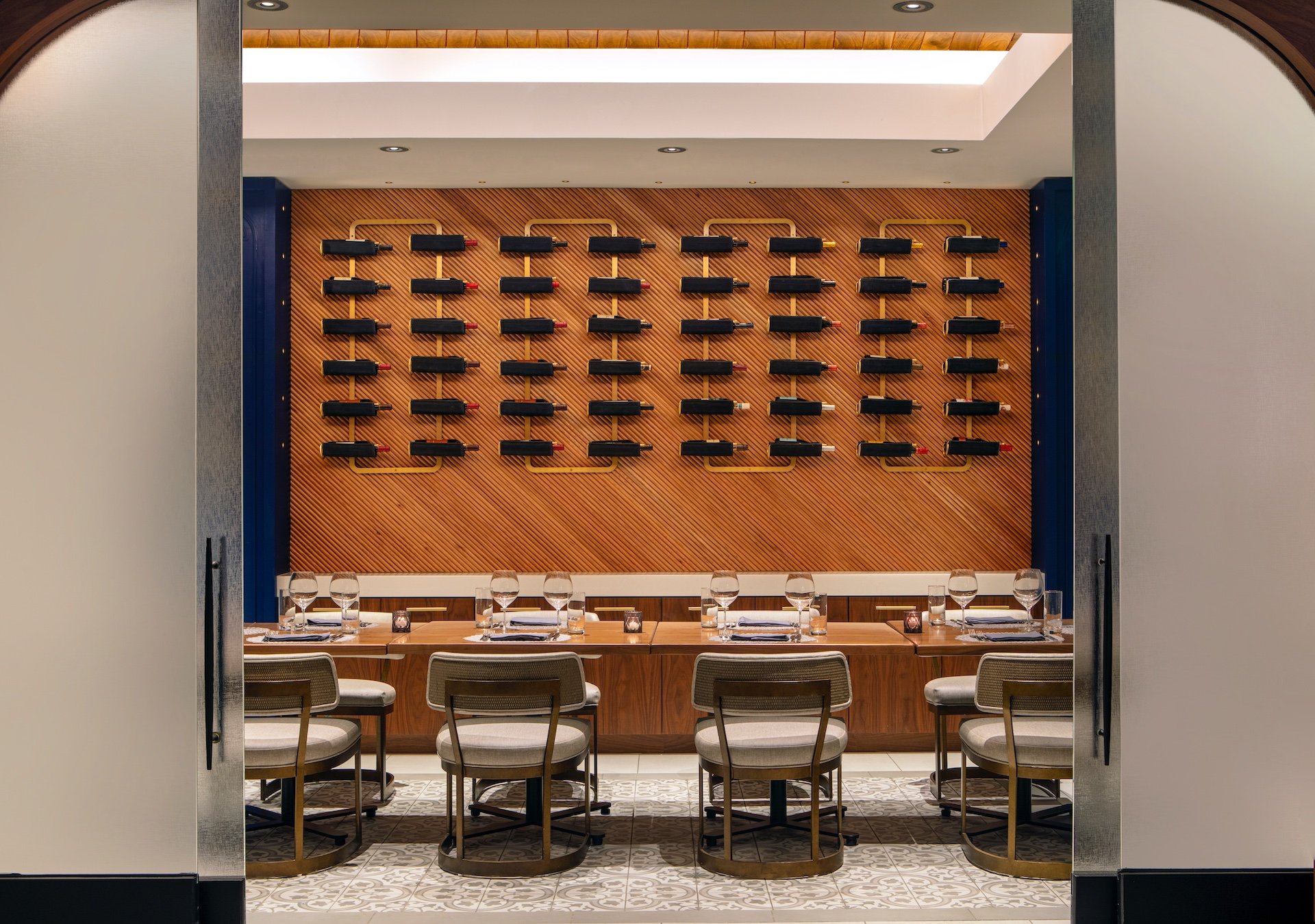 a private dining area with various bottles of wine on the wall