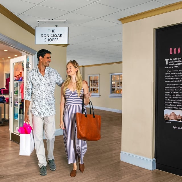 a couple walking through the halls with shopping bags in hand