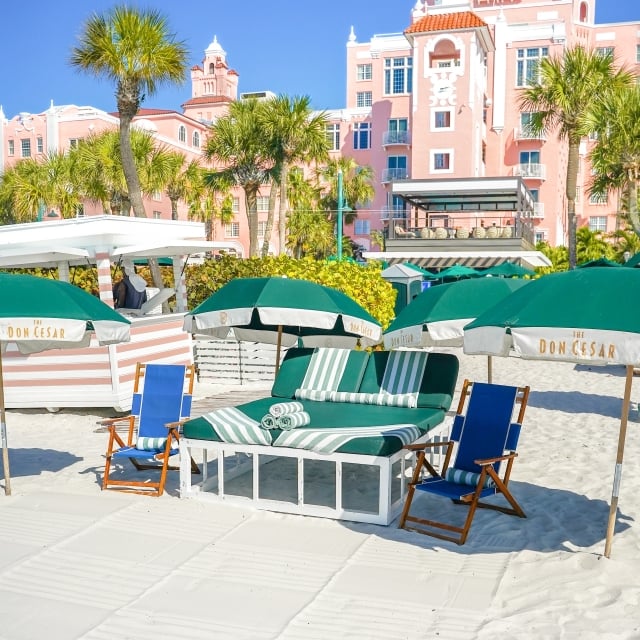 beach chairs and umbrellas on the beach in front of the Don CeSar