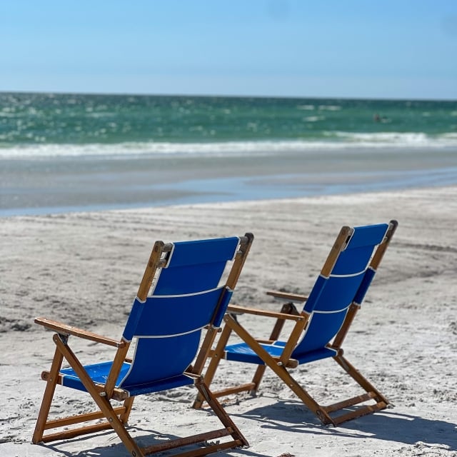 two blue beach chairs on the beach