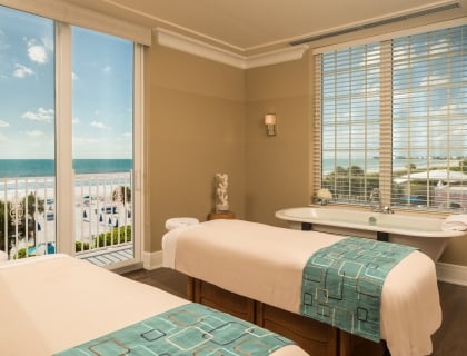 a room with two massage tables and a tub