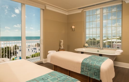 a room with two massage tables and a tub