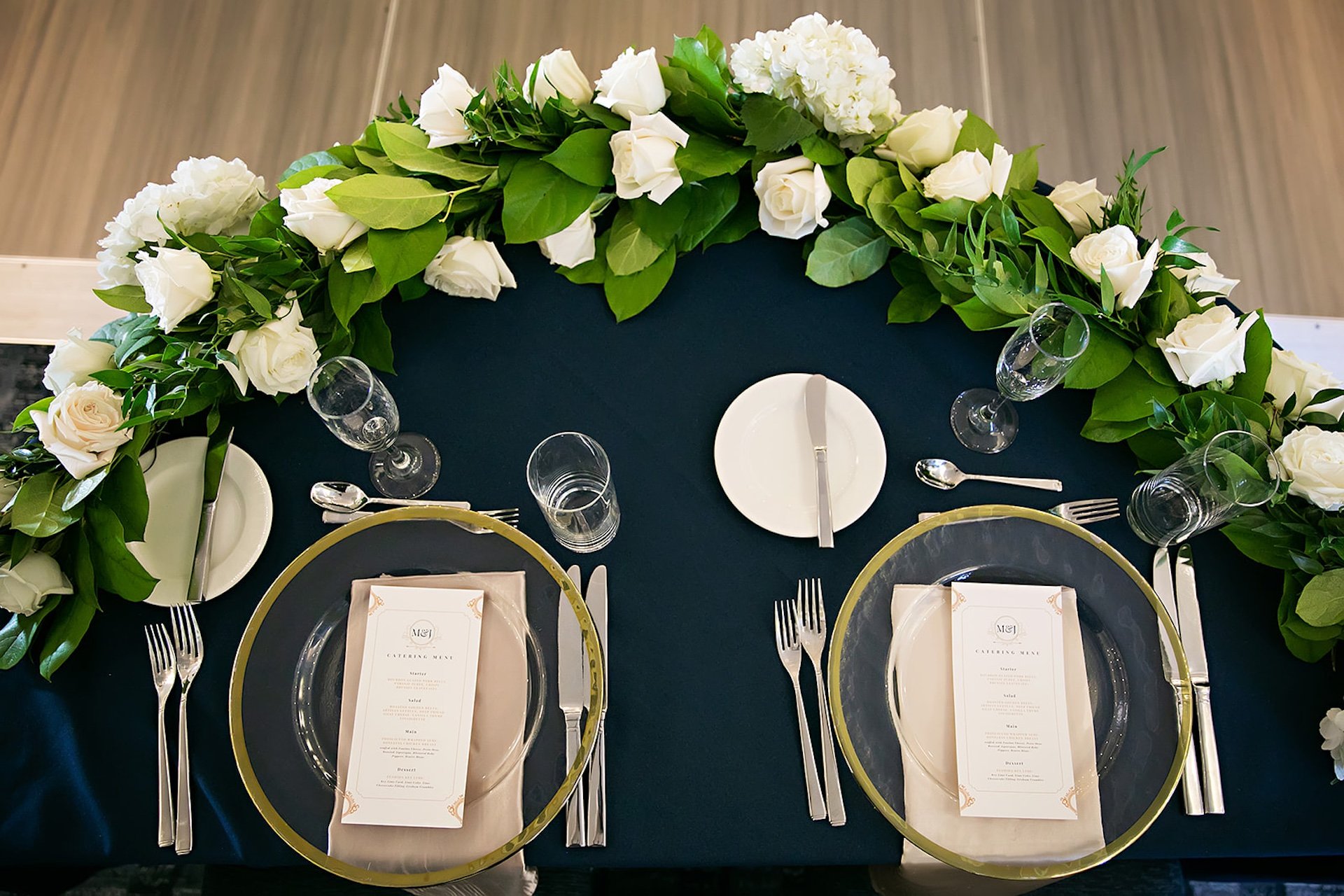 place setting with white roses and a blue table cloth