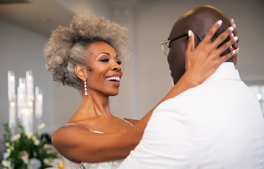 a bride holding her groom while they dance