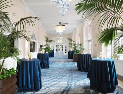 hallway with tall tables and plants