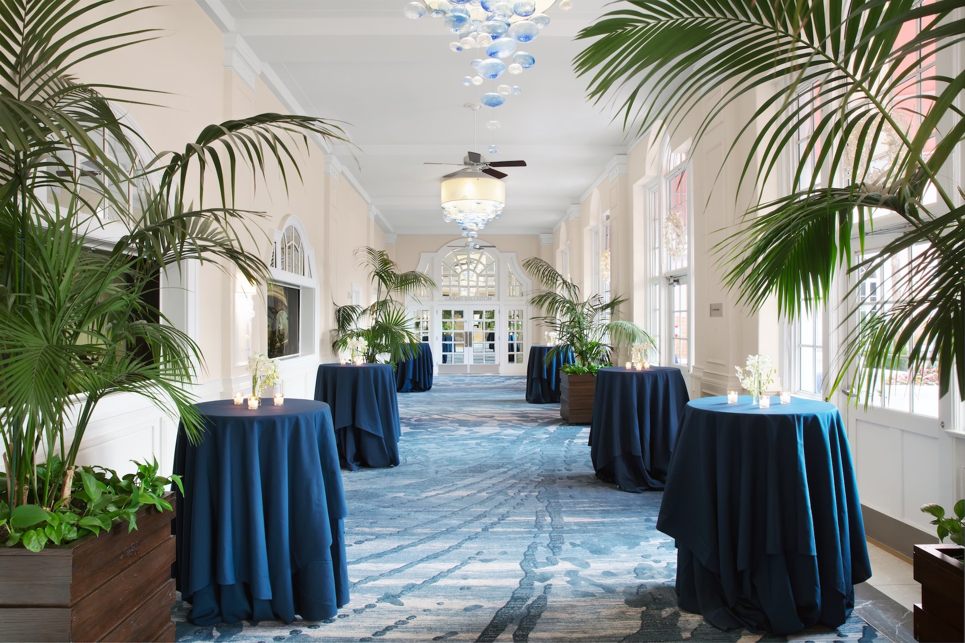 hallway with tall tables and plants