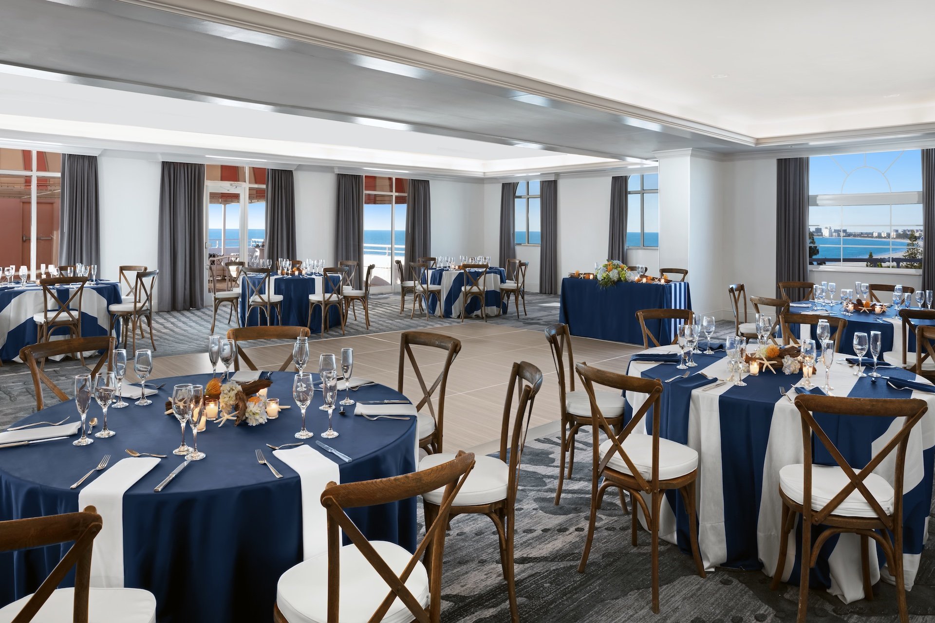 large meeting room with round tables and a view of the ocean