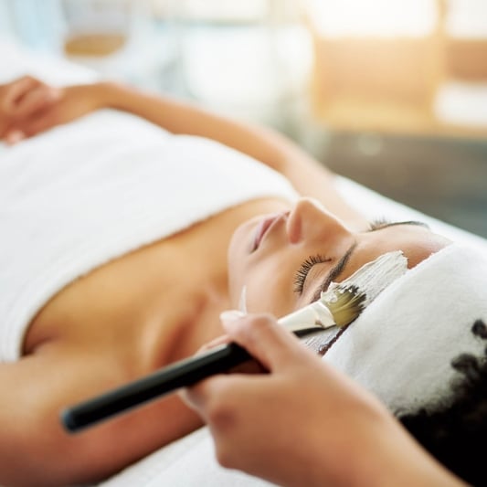 young woman getting a facial at a beauty spa