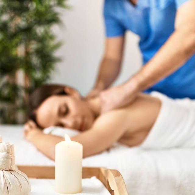 Young woman relaxed reciving back massage at beauty center.