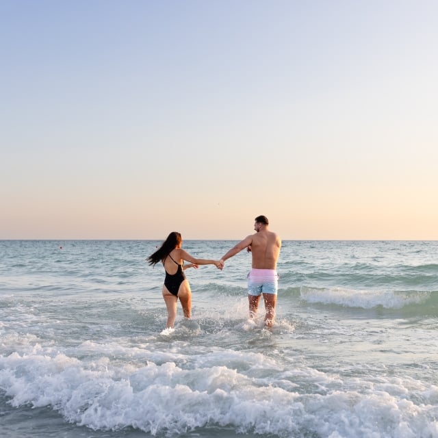 a couple running into the ocean