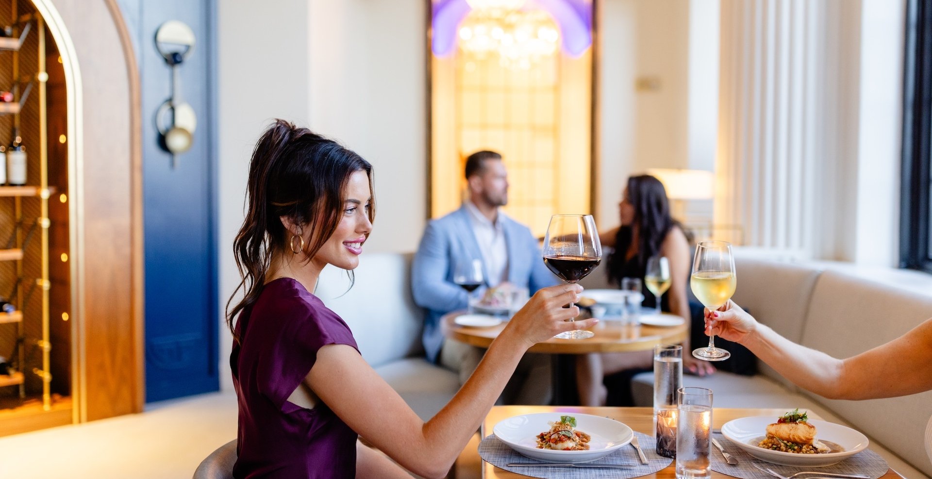 two women eating dinner and drinking wine