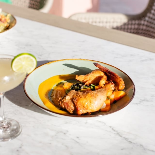 a bowl with protein and vegetables next to a margarita