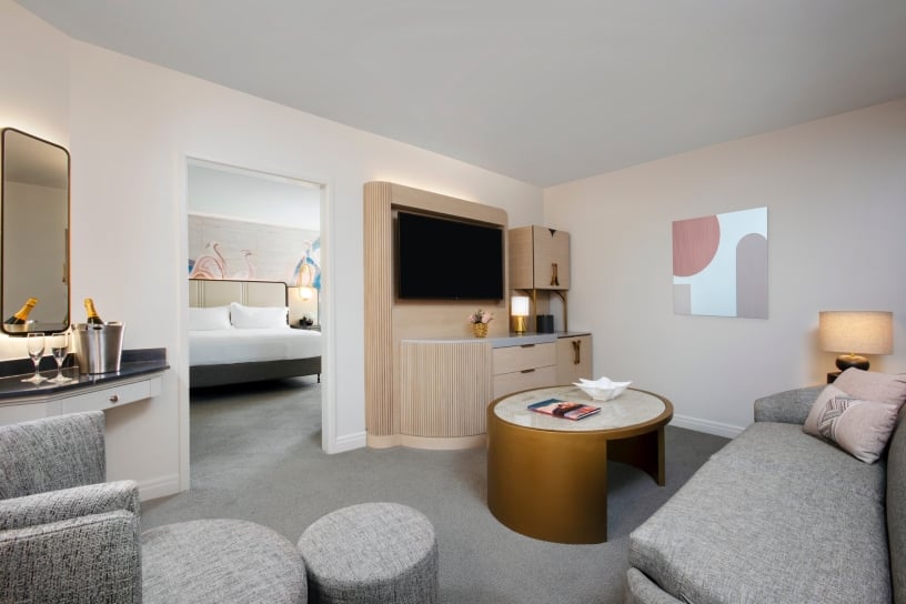 living room with grey sofa, coffee table, and tv mounted on the wall