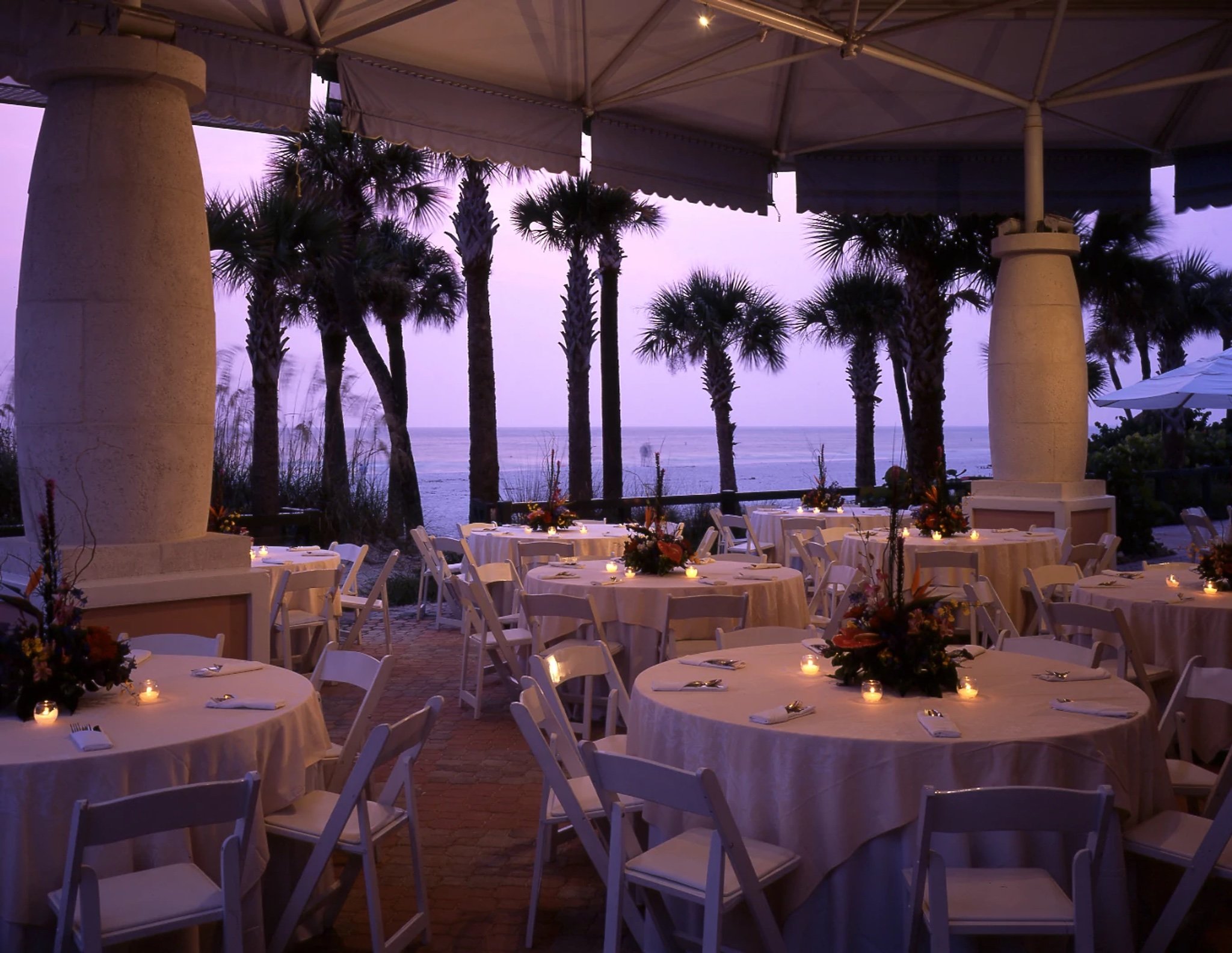 a pavilion on the beach set up for a wedding reception