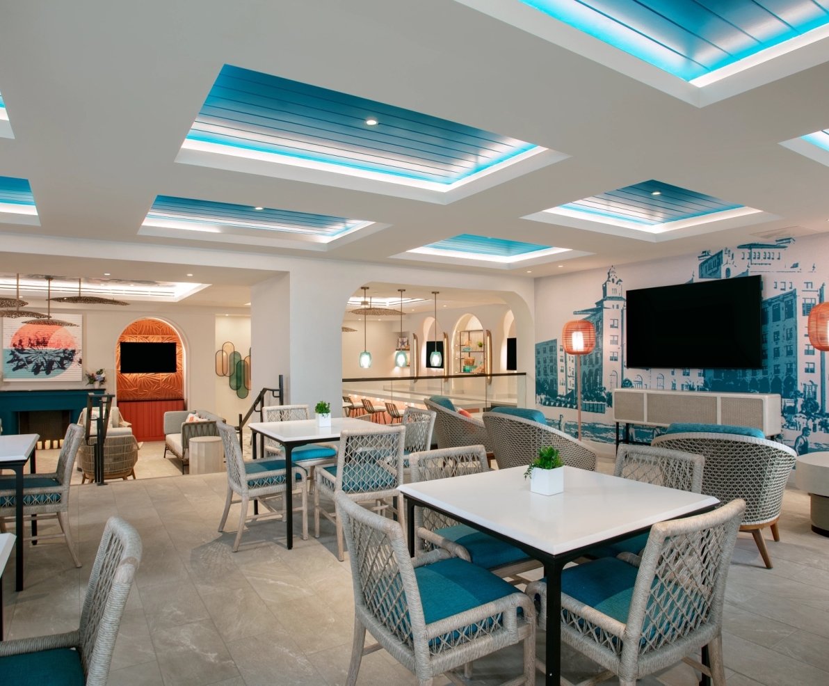 dining area with white tables and chairs and hints of teal