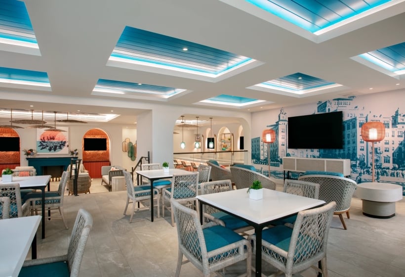 dining area with white tables and chairs and hints of teal