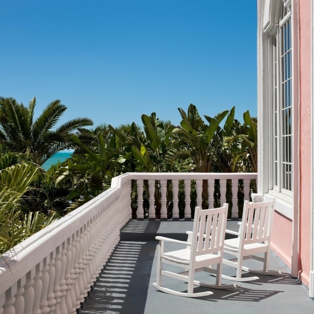 two white rocking chairs on a balcony