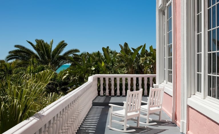 two white rocking chairs on a balcony