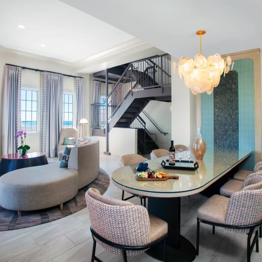 living room and dining area with grey staircase in the back