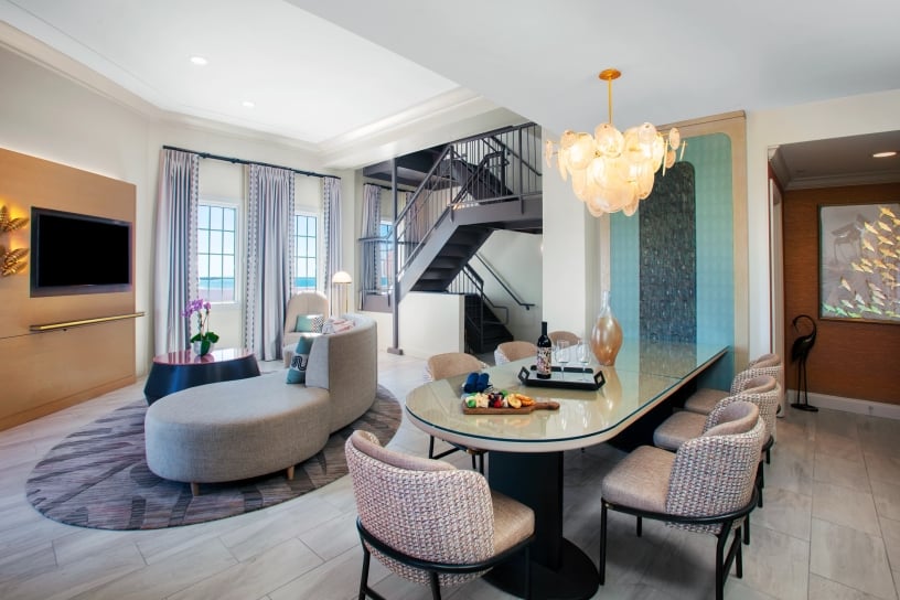 living room and dining area with grey staircase in the back