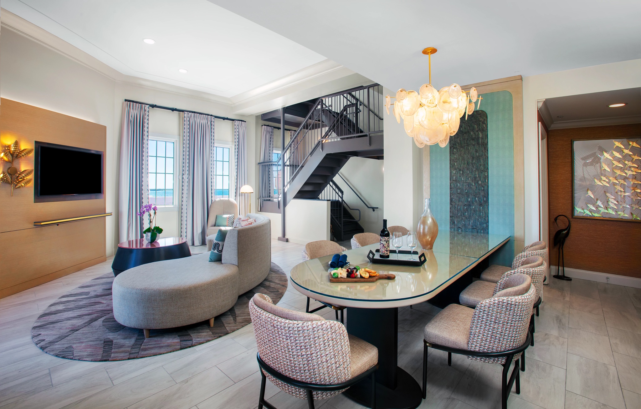 living room and dining area with grey staircase in the back