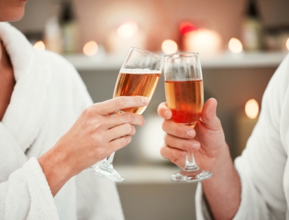 two people tapping glasses of rosé together