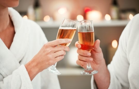 two people tapping glasses of rosé together