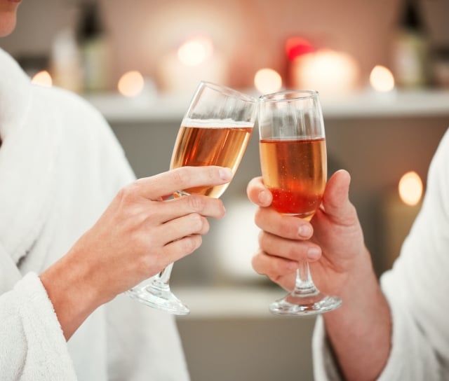 two people tapping glasses of rosé together