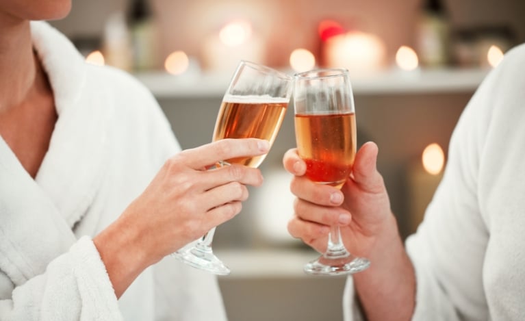 two people tapping glasses of rosé together