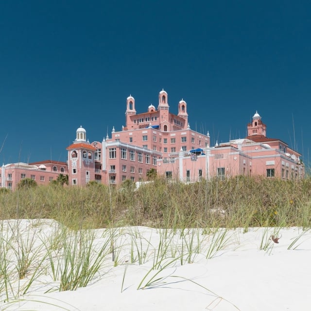 sand and grassy area on the beach in front of the hotel