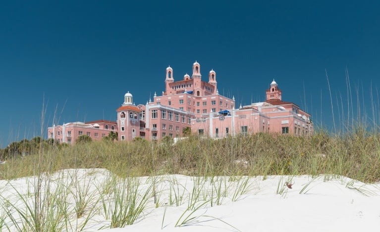 sand and grassy area on the beach in front of the hotel