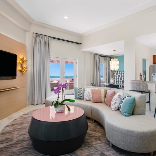 living room with grey sectional and round table with pink top