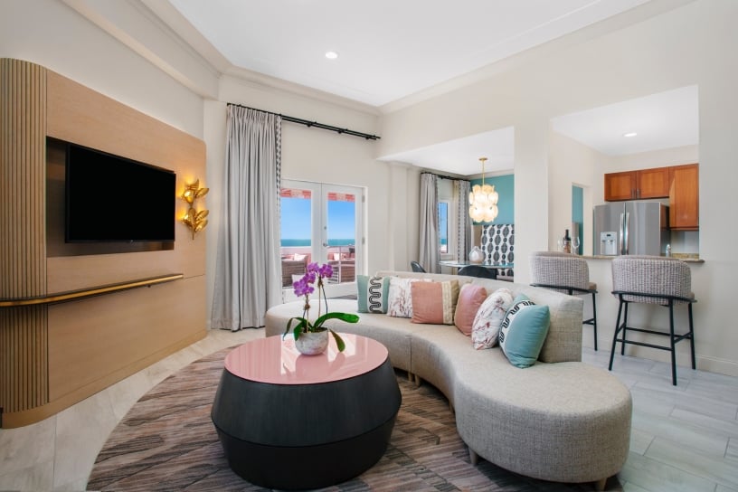 living room with grey sectional and round table with pink top