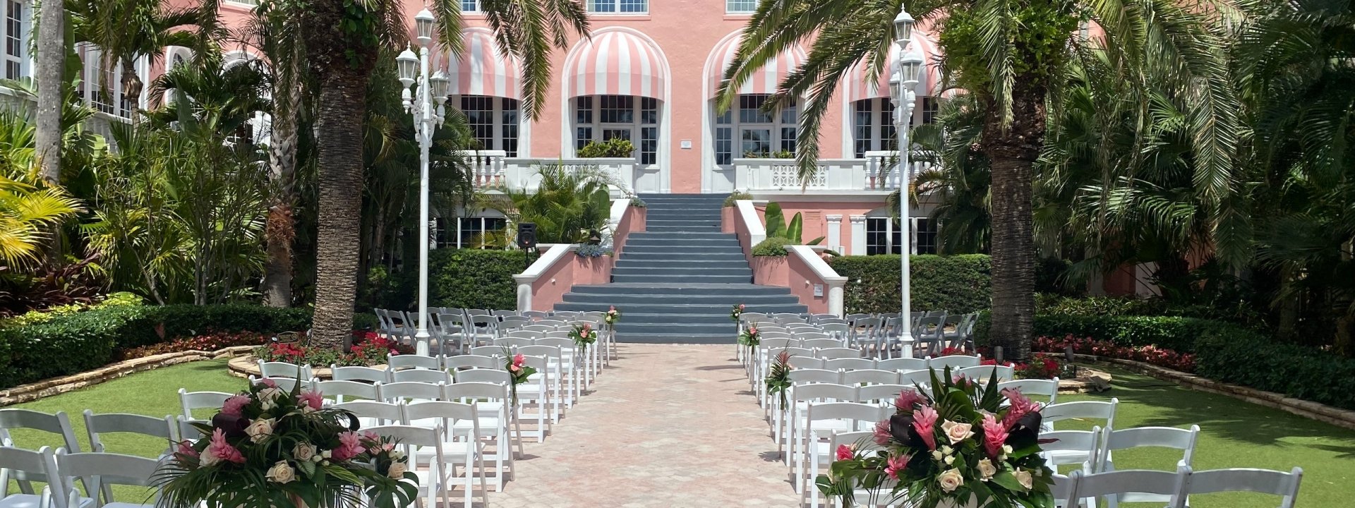 courtyard with palm trees set up with rows of chairs