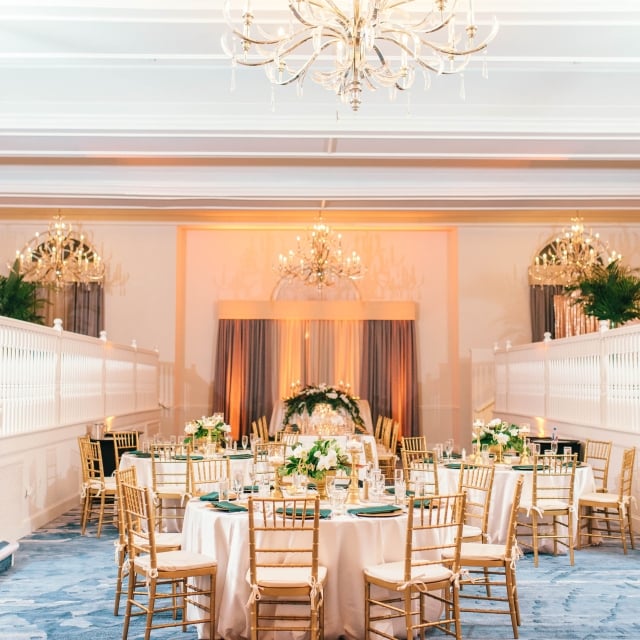 A luxurious wedding reception featuring a blue carpet and elegant chandeliers in a beautifully decorated room.