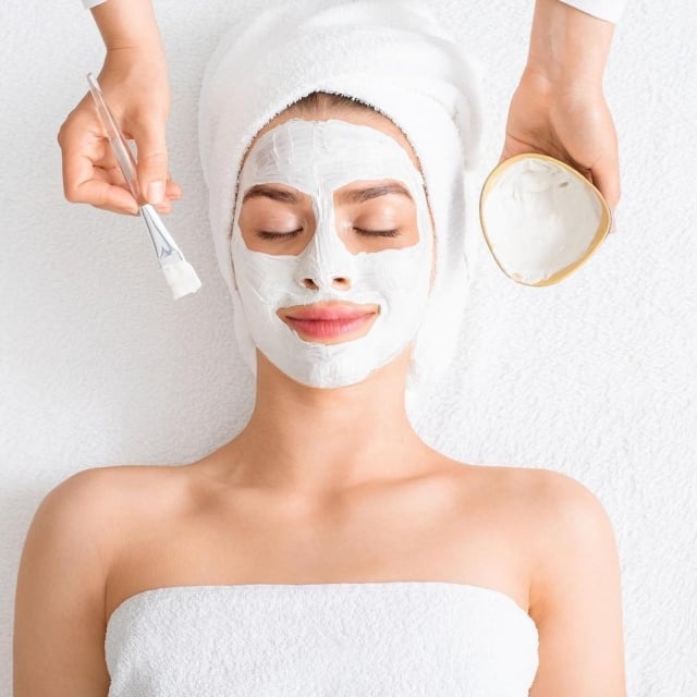 woman relaxes with a facial mask applied at a serene spa, enjoying a moment of self-care and rejuvenation.